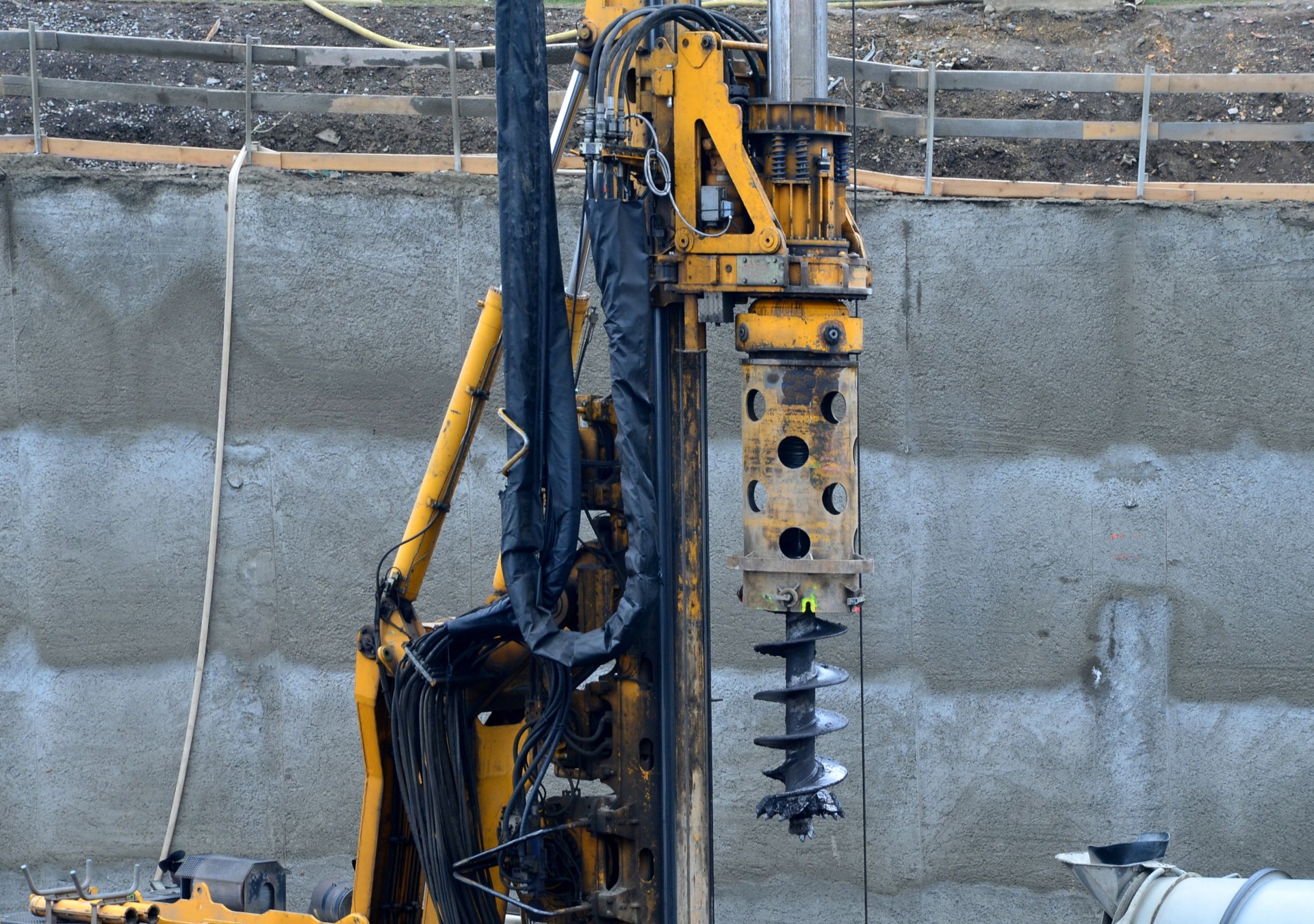 the drilling rig with a pipe drill drills holes for concreting the foundation columns and grouting the subsoil. wire reinforcing mesh cylinder shape, ready for installation on site, wrapped, trunk